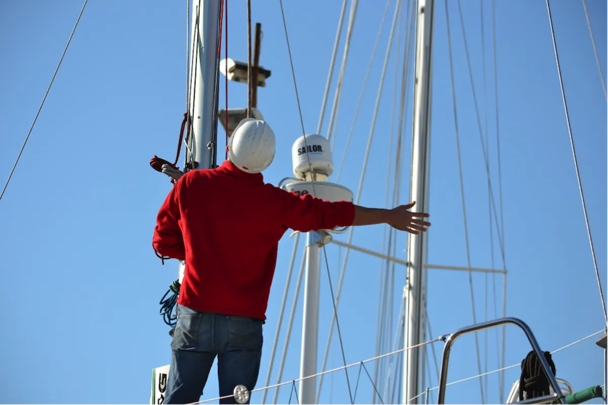 a man next to a sailboat mast